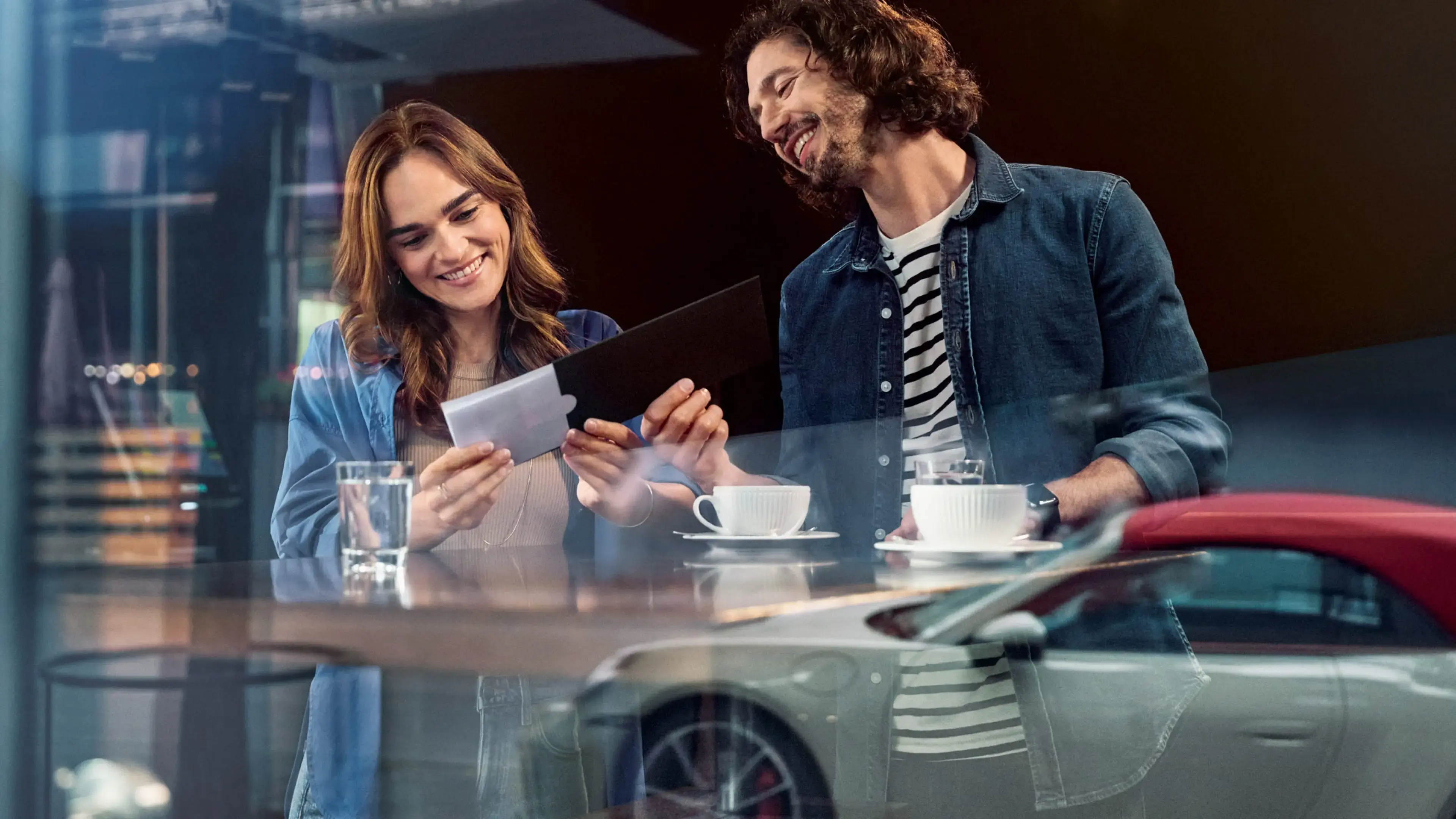 Two people opening an envelope with a voucher inside